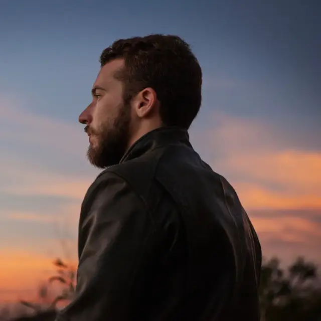 Lässiger Mann im weißen T-Shirt am Strand bei Sommerwetter – stylisches Sommer T-Shirt für Herren