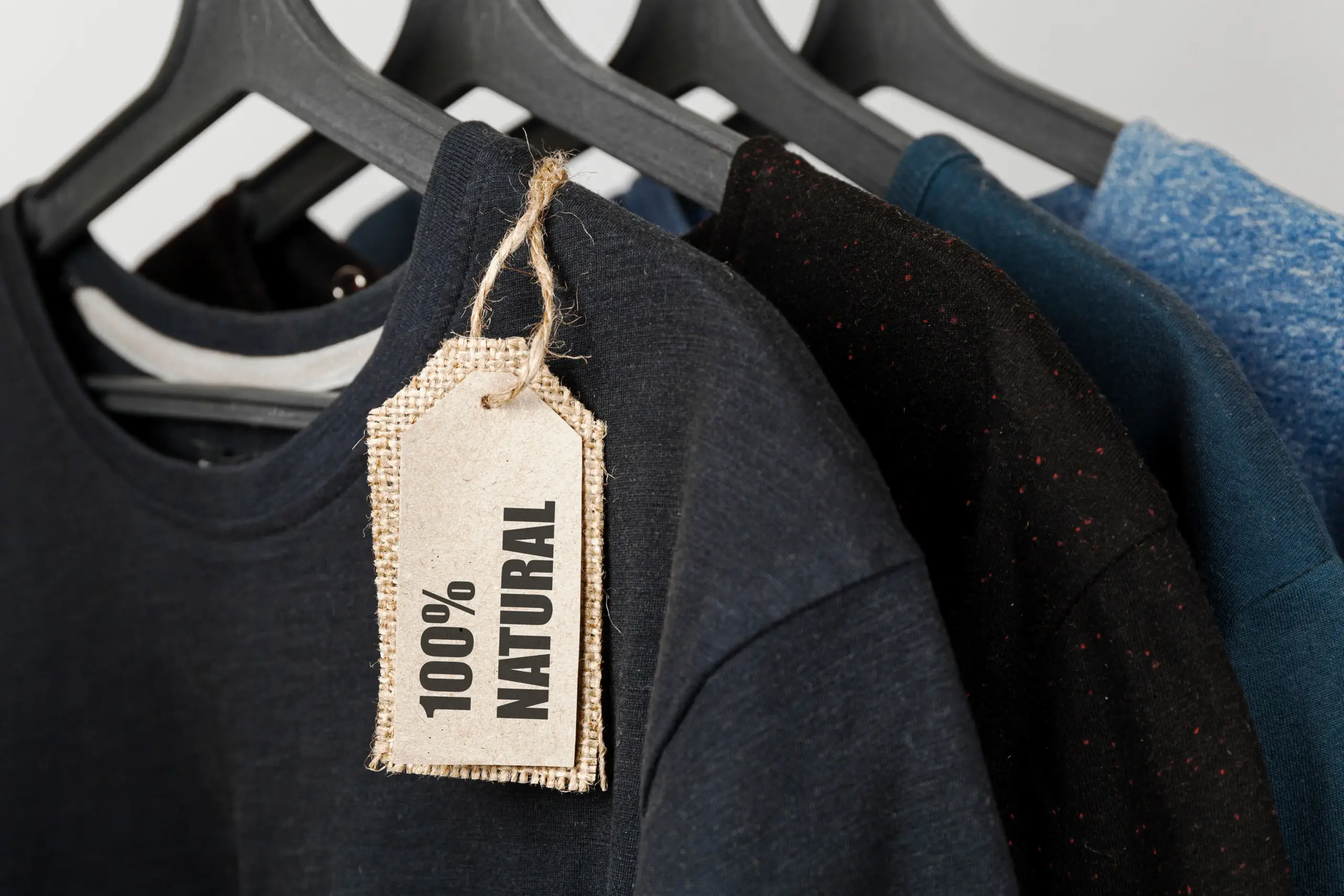 Clothing made from 100% natural materials – bio T-shirts on hangers with sustainability tags